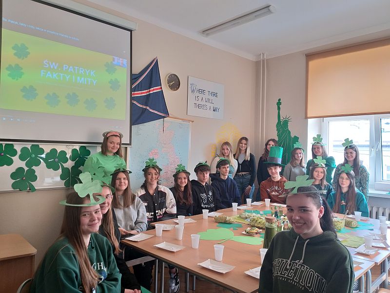 Grupa uczniów dookoła stołu z zielonymi wypiekami