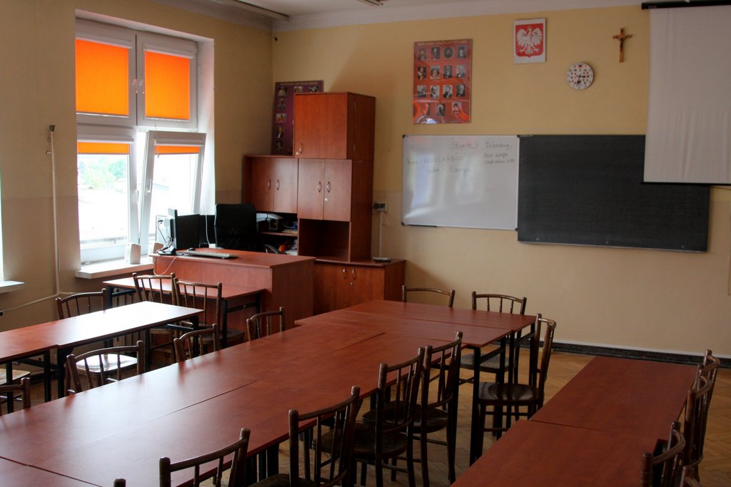 Fotografia sali lekcyjnej - ustawione ławki, pomoce dydaktyczne, ozdoby.
